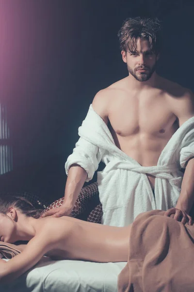 Сексуальная женщина на курортном массаже с бородатым красавчиком-терапевтом — стоковое фото