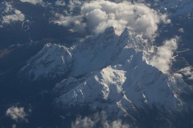 Pastoral karlı dağ zirveleri bulutlar düzlem altında
