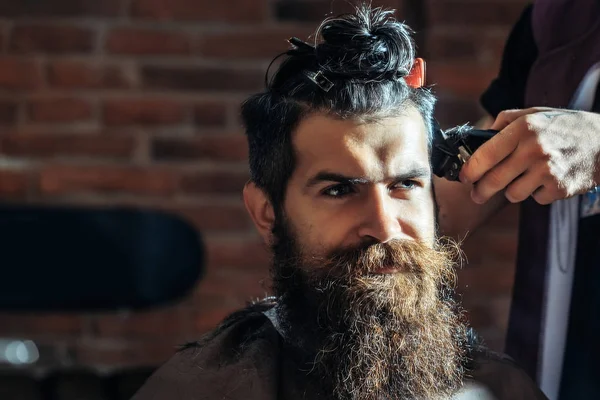 Бородатый мужчина с бородой стрижется парикмахером в парикмахерской — стоковое фото