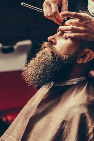Bebaarde man met lange baard krijgen haar scheren met een scheermes — Stockfoto