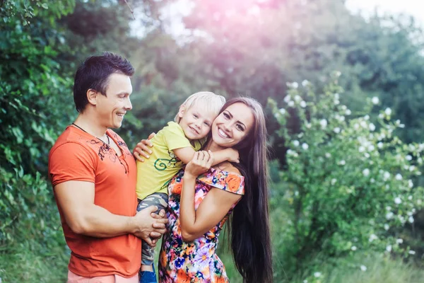 Happy smiling family in green summer park — Stock Photo, Image