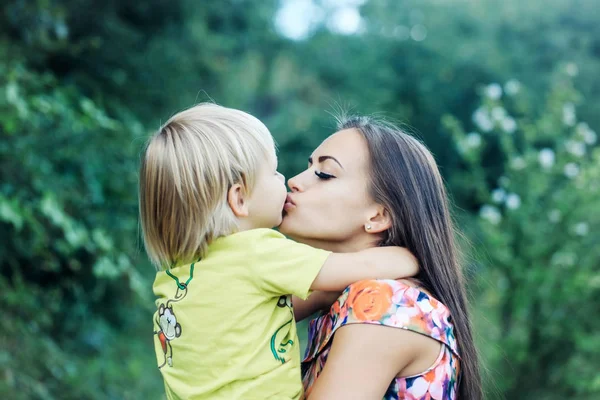 Cute little child kissing and hugging pretty mother — Stock Photo, Image