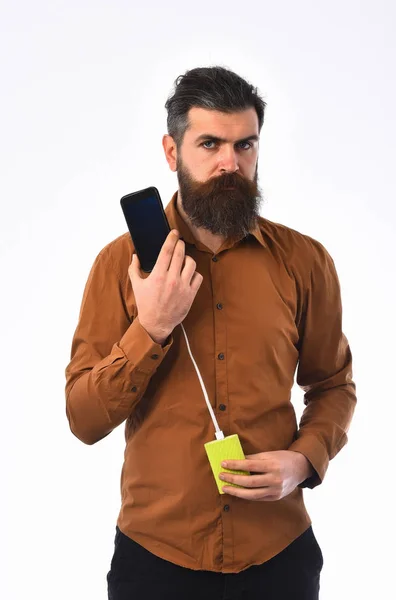 Pria berjenggot serius hipster pengisian ponsel dengan bank listrik — Stok Foto