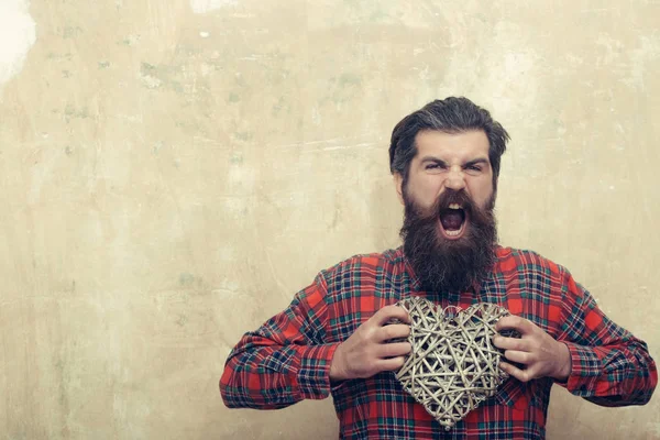 Boos bebaarde man met lange baard houdt rieten hart — Stockfoto