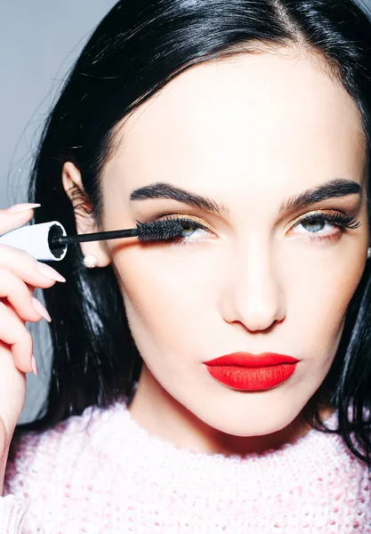 Kırmızı dudaklar ve uzun saçlı seksi kadınla tutun rimel