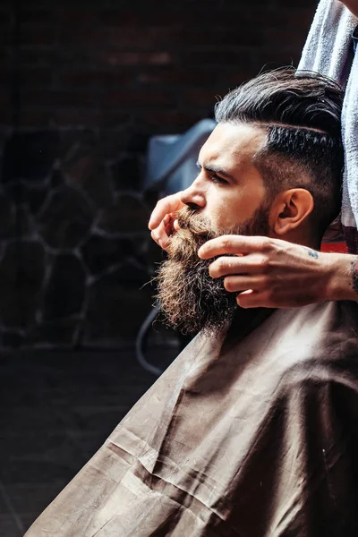 Bearded man getting long beard styling