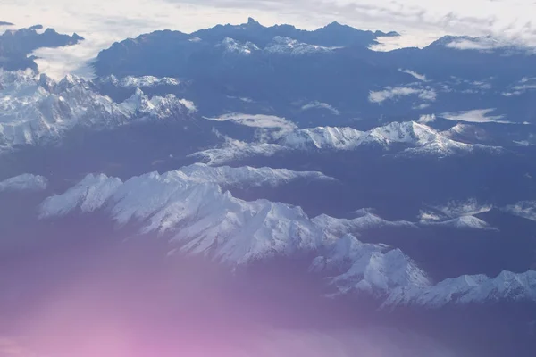 田园白雪皑皑的山峰下从飞机云 — 图库照片