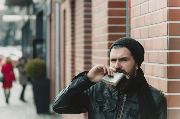 Serious bearded man hipster with metallic jar in leather jacket — Stock Photo, Image