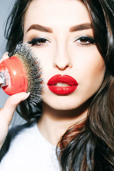 Mulher sexy com lábios vermelhos, cabelos longos segura escova de ferro — Fotografia de Stock