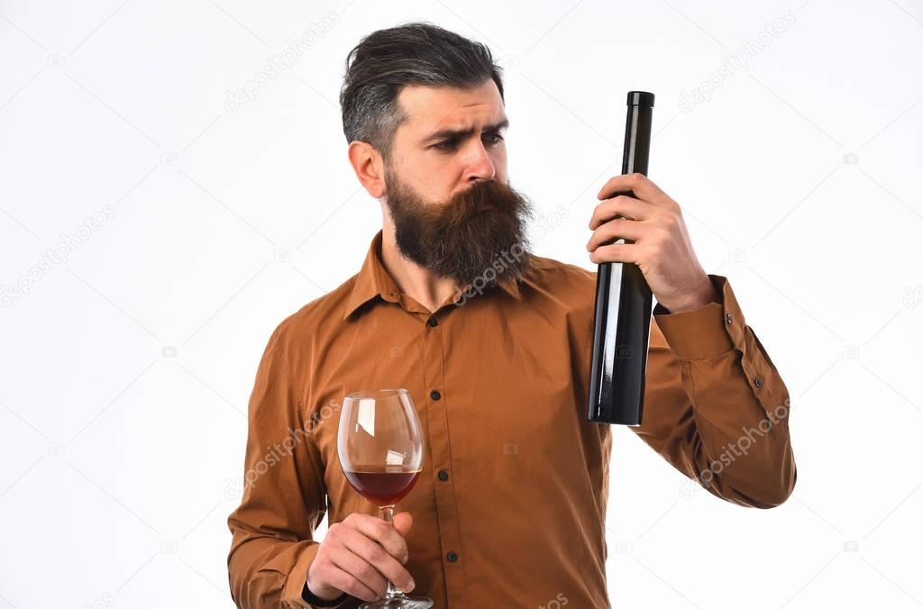 bearded man hipster with wine bottle, glass in brown shirt