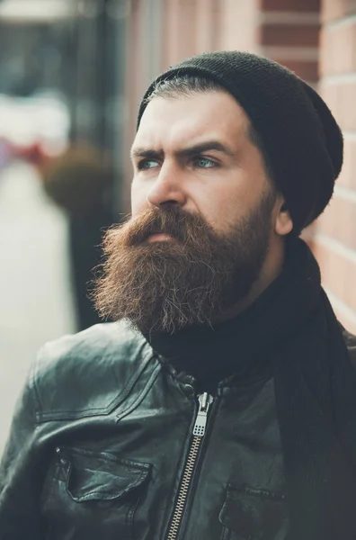 Bebaarde man hipster met ernstige gezicht in lederen jas — Stockfoto