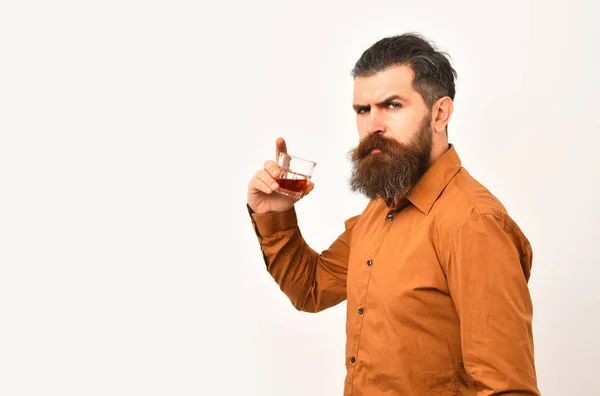 Ernster bärtiger Mann Hipster mit Whiskeyglas im orangefarbenen Hemd — Stockfoto