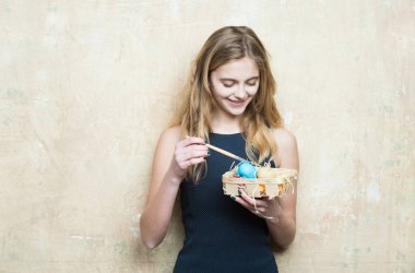 Mutlu Paskalya sarışın kız ressam renkli yumurta ve boya fırçası ile