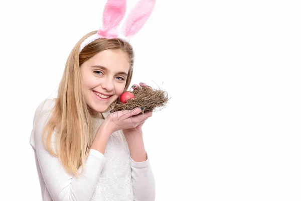 Щаслива великодня дівчина в вухах кролика з червоним розфарбованим яйцем — стокове фото
