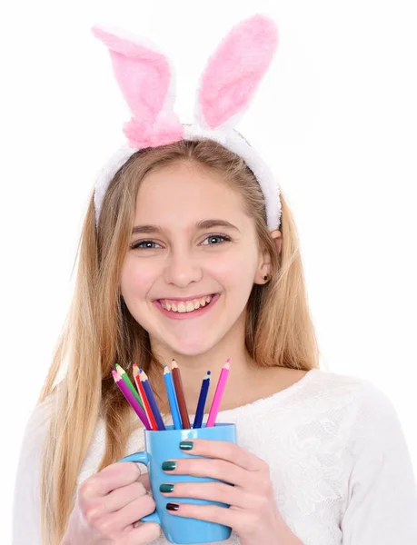 Chica feliz en orejas de conejo con lápiz de colores en la taza —  Fotos de Stock