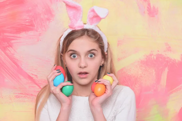 Feliz chica de Pascua en orejas de conejo con coloridos huevos pintados — Foto de Stock