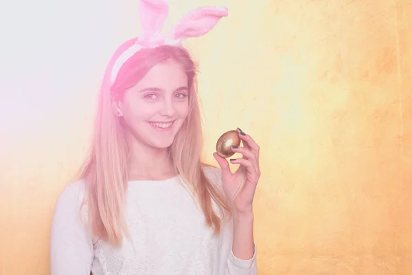 Feliz chica de Pascua en orejas de conejo con huevo de oro — Foto de Stock