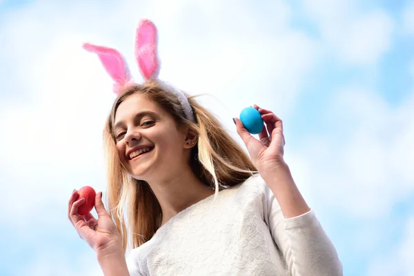 Feliz chica de Pascua con orejas de conejo, huevos en el cielo azul —  Fotos de Stock