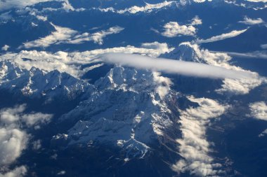 Pastoral karlı dağ zirveleri bulutlar düzlem altında