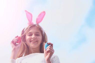 Mutlu Paskalya kız tavşan kulaklı yumurta üzerinde mavi gökyüzü