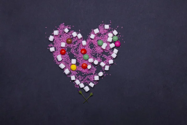 Doces de dragee coloridos, marshmallow, zephyr e polvilhas em forma de coração — Fotografia de Stock