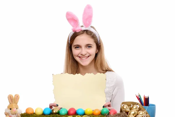 Feliz chica de Pascua en orejas de conejo con huevos, hoja de papel — Foto de Stock