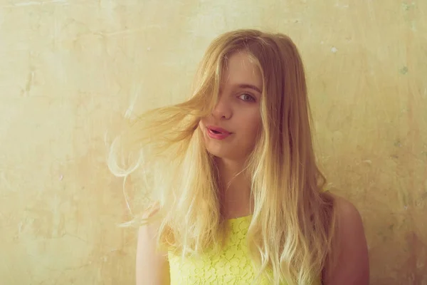 Довольно счастливая девушка с длинными светлыми волосами в желтом платье — стоковое фото