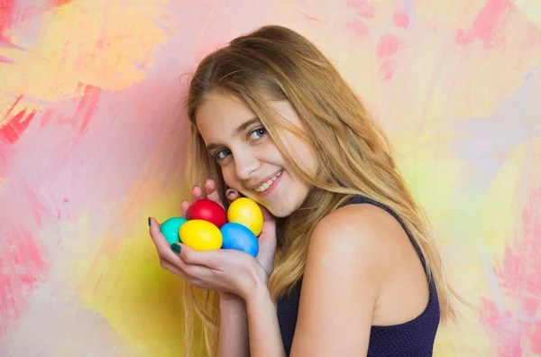 Feliz Pascua rubia chica con coloridos huevos en las manos —  Fotos de Stock