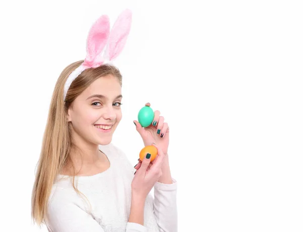 Feliz chica de Pascua en orejas de conejo con coloridos huevos pintados — Foto de Stock