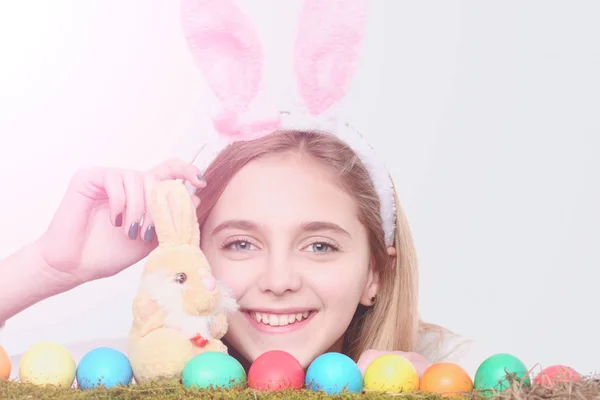 Feliz chica de Pascua en orejas de conejo con huevos de colores, conejo —  Fotos de Stock