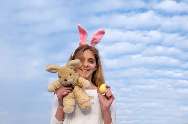 Щаслива великодня дівчина з вухами кролика, яйце на блакитному небі — стокове фото