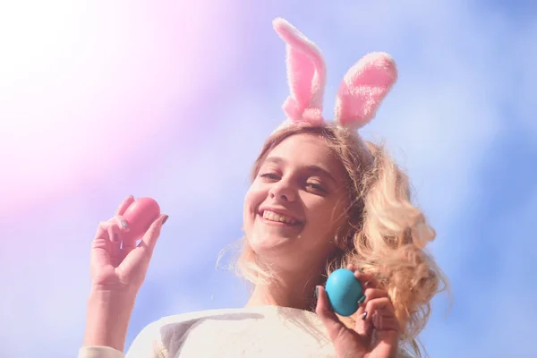 Gelukkig Pasen meisje met bunny oren, eieren op blauwe hemel — Stockfoto