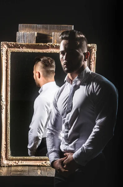 Macho muscular hombre con sexy atleta cuerpo cerca de espejo vintage — Foto de Stock