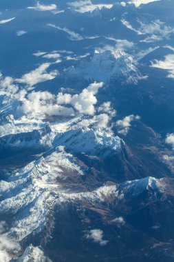 Pastoral karlı dağ zirveleri bulutlar düzlem altında