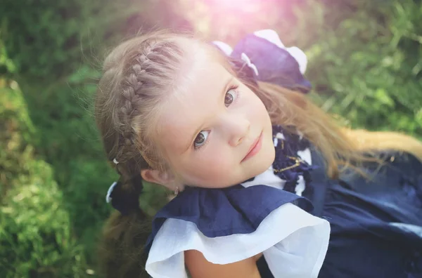 Feliz linda chica con pelo trenzado sonriendo en la hierba verde — Foto de Stock