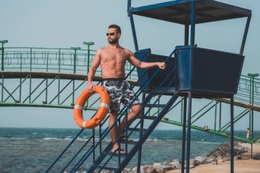 Sakallı cankurtaran veya turuncu yüzük şamandıra ile kas adam