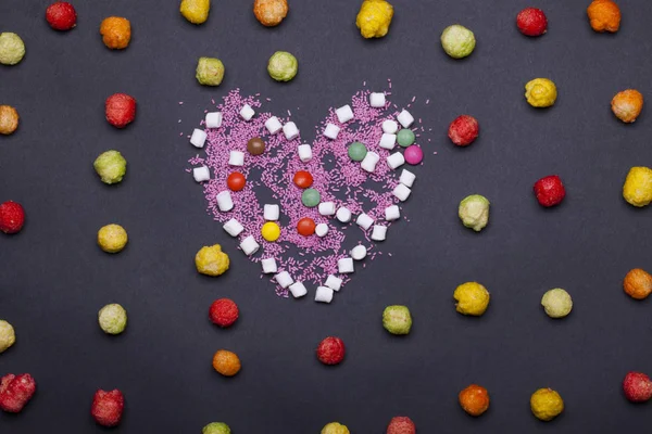 Colorful dragee sweets, marshmallow, zephyr and sprinkles in heart shape — Stock Photo, Image