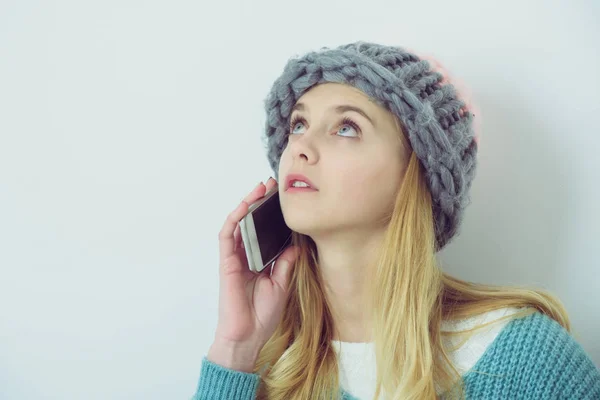 漂亮的年轻女孩穿着毛衣，帽子与移动电话 — 图库照片