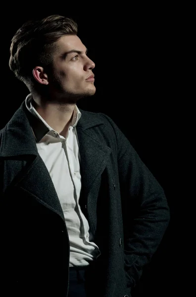 Yakışıklı adam beyaz gömlek ve karanlık kat poz — Stok fotoğraf