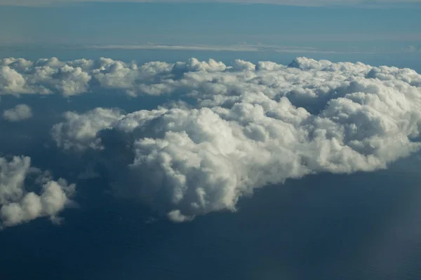 Dicke flauschige weiße Wolken am blauen Himmel über dem idyllischen Meer — Stockfoto