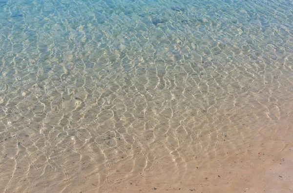 Agua superficial del mar o del océano sobre fondo de arena —  Fotos de Stock