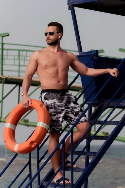 Γενειοφόρος lifeguard ή μυώδης άνδρας με πορτοκαλί δαχτυλίδι σημαντήρα — Φωτογραφία Αρχείου