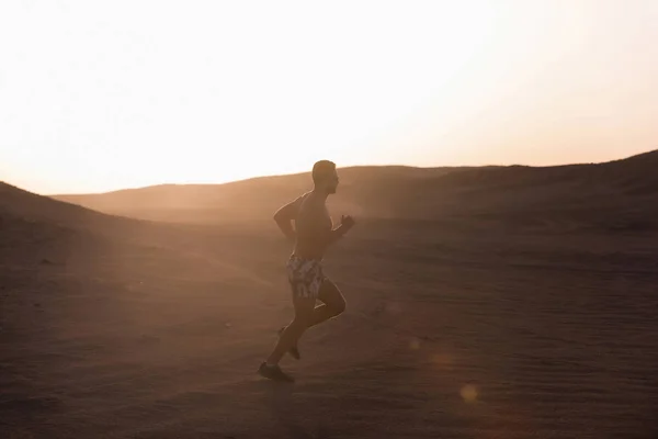 Man runner uitgevoerd in Duin bij zonsondergang — Stockfoto
