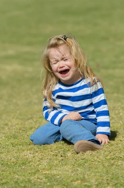 불행 한 귀여운 아기 공원에서 푸른 잔디에 앉아 — 스톡 사진