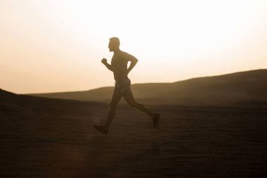 Dune günbatımında çalışan adam runner