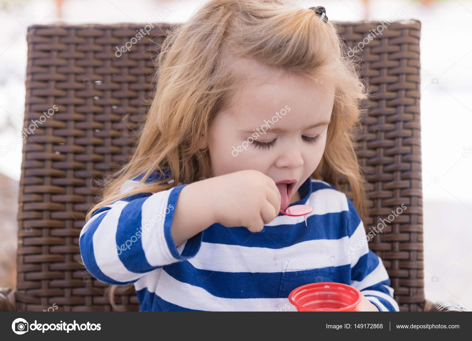 Cute Baby Boy Eating Tasty Ice Cream In Outdoor Cafe Stock Photo