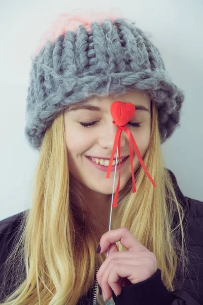 Pretty young happy girl in fashionable hat with red heart — Stock Photo, Image