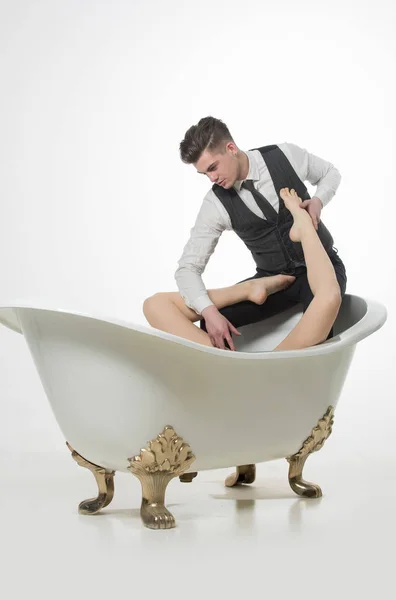 Schöner Mann entspannt sich mit sexy nackten weiblichen Beinen in der Badewanne — Stockfoto