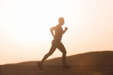 Dune günbatımında çalışan adam runner