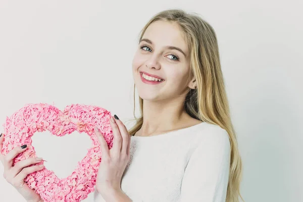 Ziemlich glückliches Mädchen mit rosa Weidenherz zum Valentinstag — Stockfoto